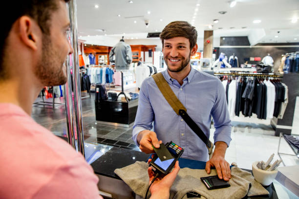 Apparel POS System | PUREJOIN Clothing Store Payment Processing Customer making a card payment at a clothing store checkout counter using a POS terminal, demonstrating convenient payment processing with an apparel POS system.